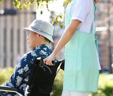 車椅子の男性を押す女性